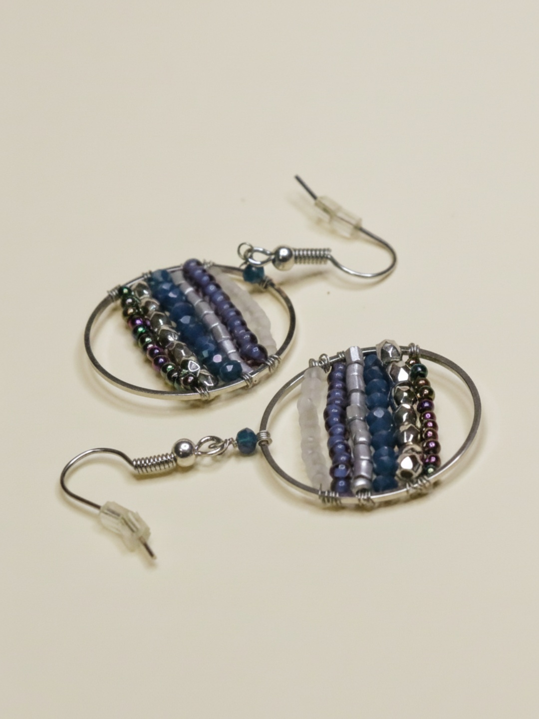 Pendientes colgantes de aro con abalorios en diagonal sobre fondo claro — lote de pendientes dorados, primer plano · Lola y Sol (EAR-078)