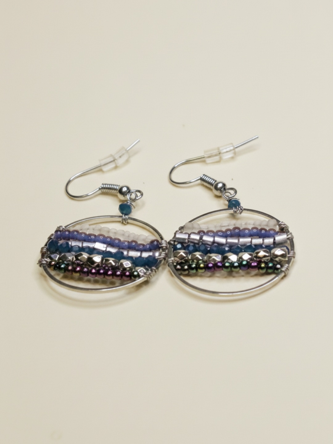Pendientes de aro plateado con hileras de abalorios de colores sobre fondo claro — lote de pendientes de moda, vista lateral · Lola y Sol (EAR-078)