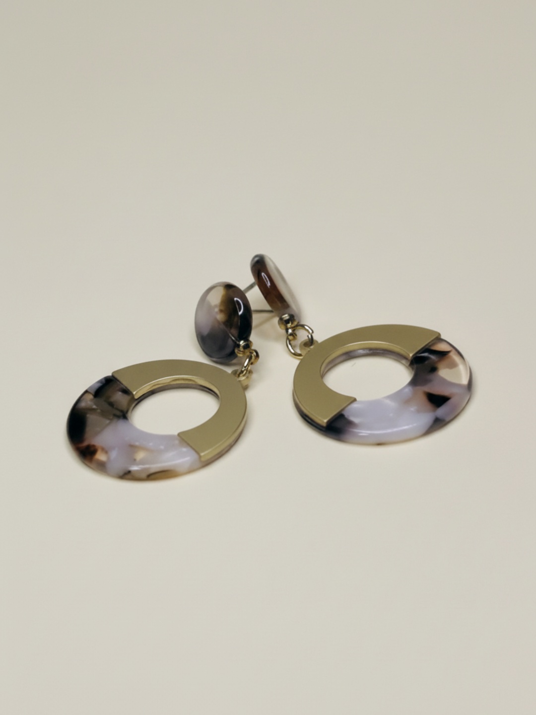 Pendientes circulares dorados y rosa pálido marmoleado sobre fondo beige — pendientes de moda, vista lateral · Lola y Sol (EAR-082)