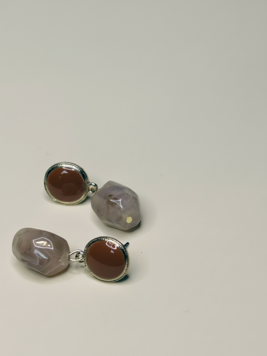 Pendientes colgantes marrones y beige sobre fondo claro — pendientes dorados, primer plano · Lola y Sol (EAR-088)