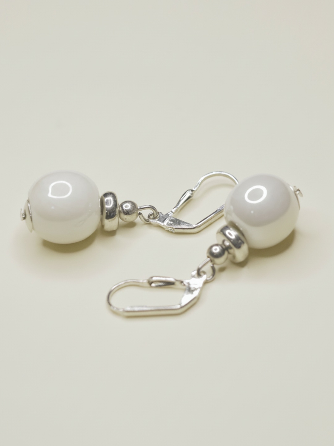 Pendientes colgantes con cuenta blanca y detalles plateados sobre fondo claro — pendientes para mujer, vista principal · Lola y Sol (EAR-092)