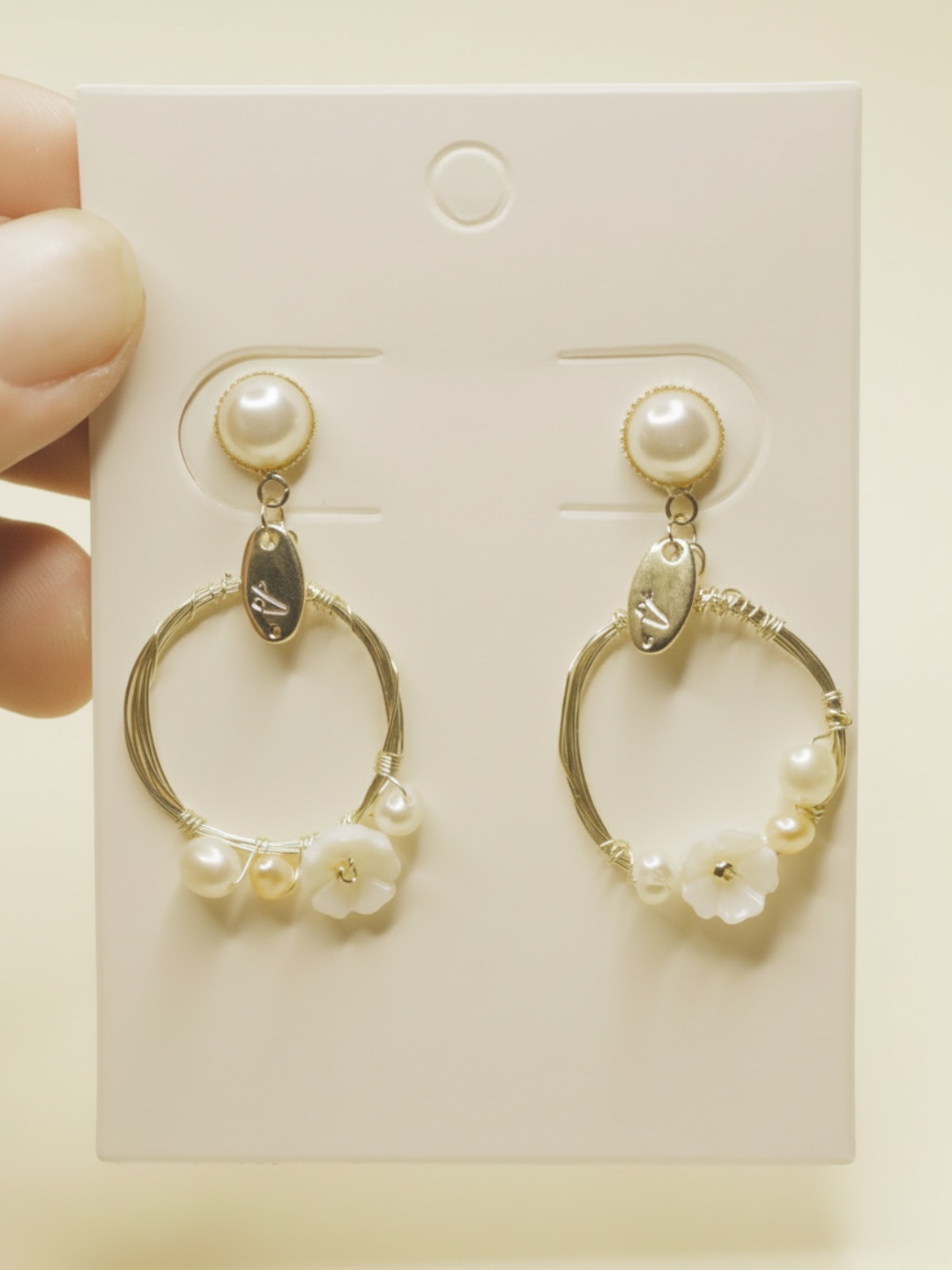 Pendientes de aro dorados con flores sobre tarjeta blanca — pendientes dorados, primer plano · Lola y Sol (EAR-095)
