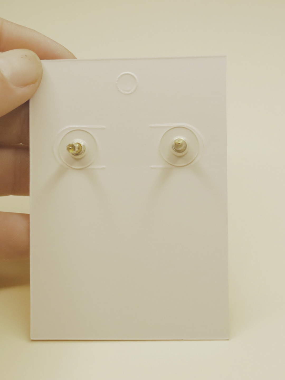 Reverso de la tarjeta con los cierres de los pendientes — pendientes dorados, primer plano · Lola y Sol (EAR-098)