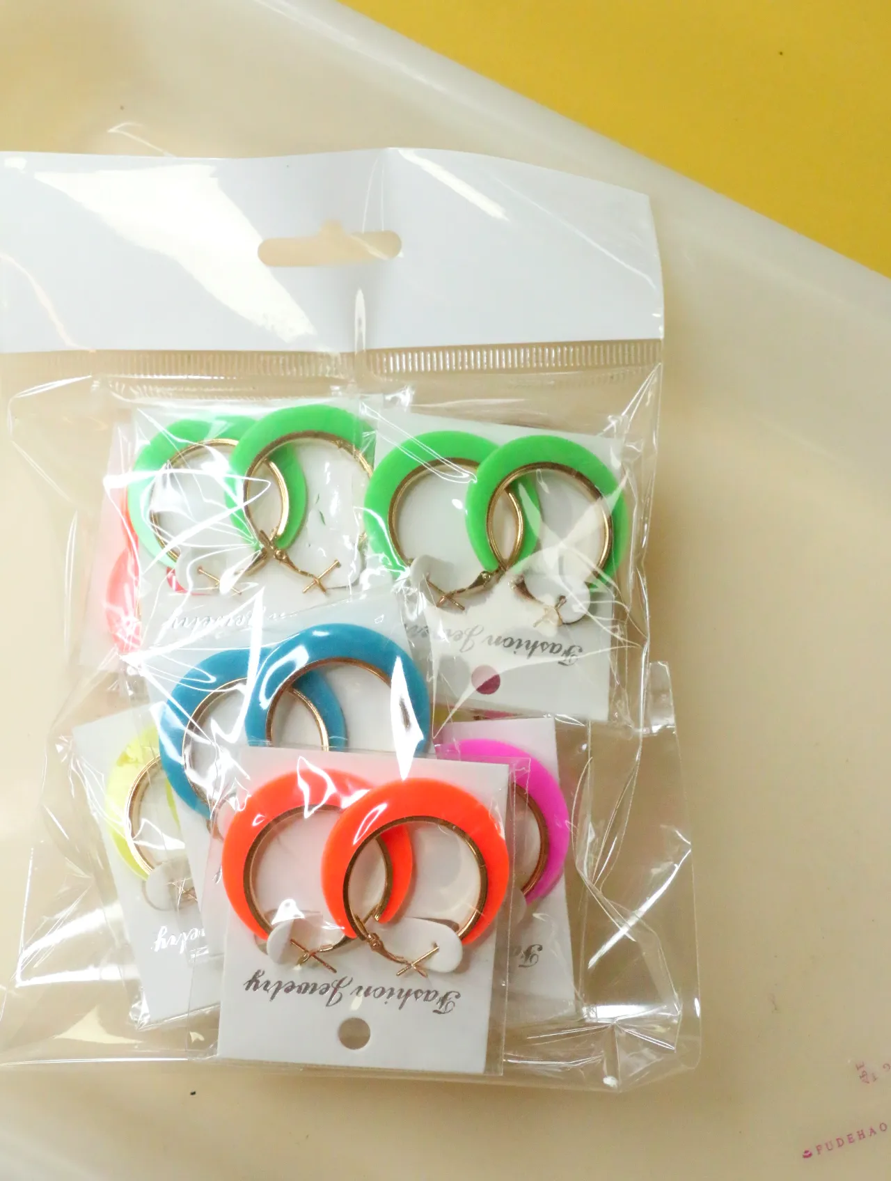 Bolsa de pendientes de aro en colores vivos — lote de bisutería dorados, primer plano · Lola y Sol (H0007)