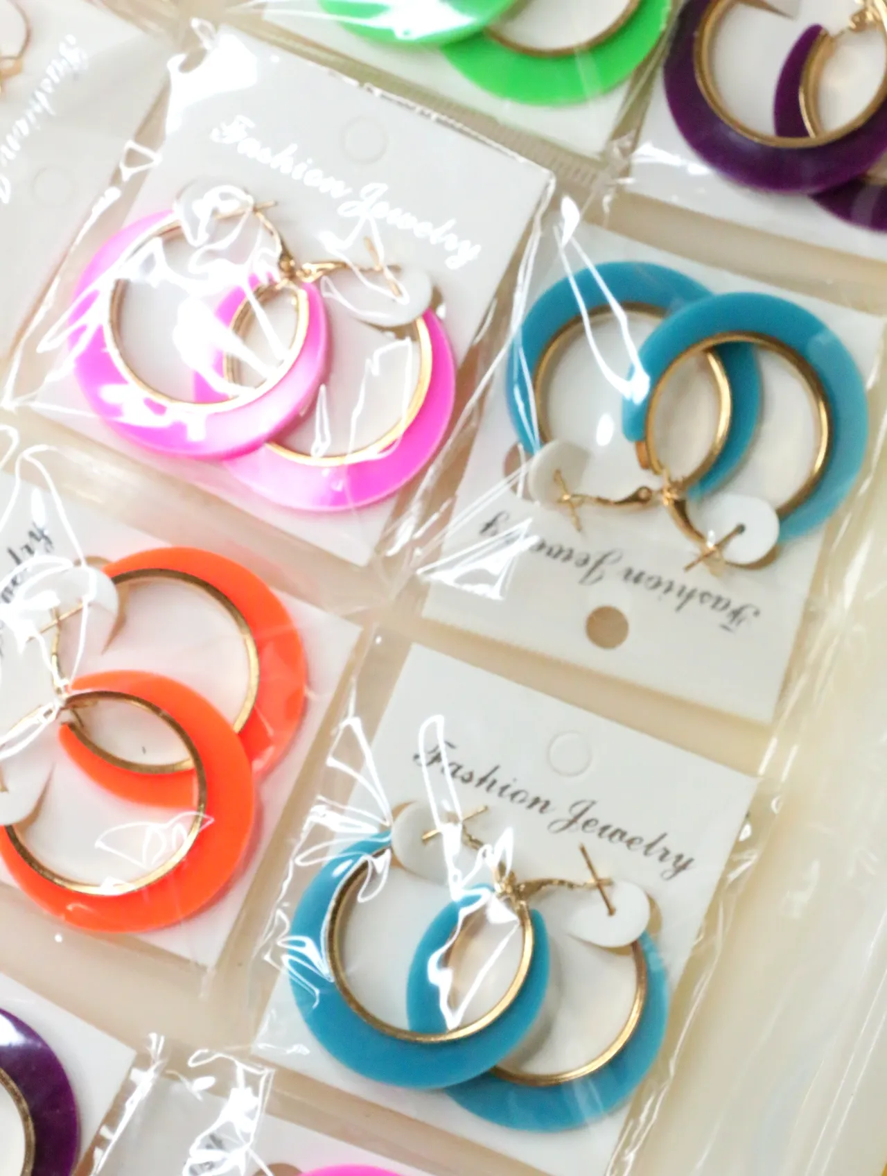 Detalle de aros de colores con acabado dorado — lote de bisutería de moda, vista lateral · Lola y Sol (H0007)