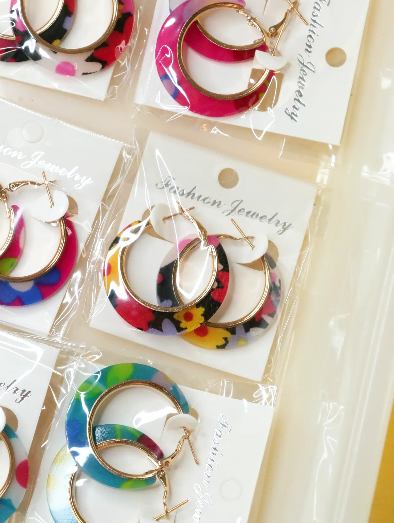 Pendientes de aro florales variados con detalles dorados — lote de bisutería baratos, detalle · Lola y Sol (H0008)
