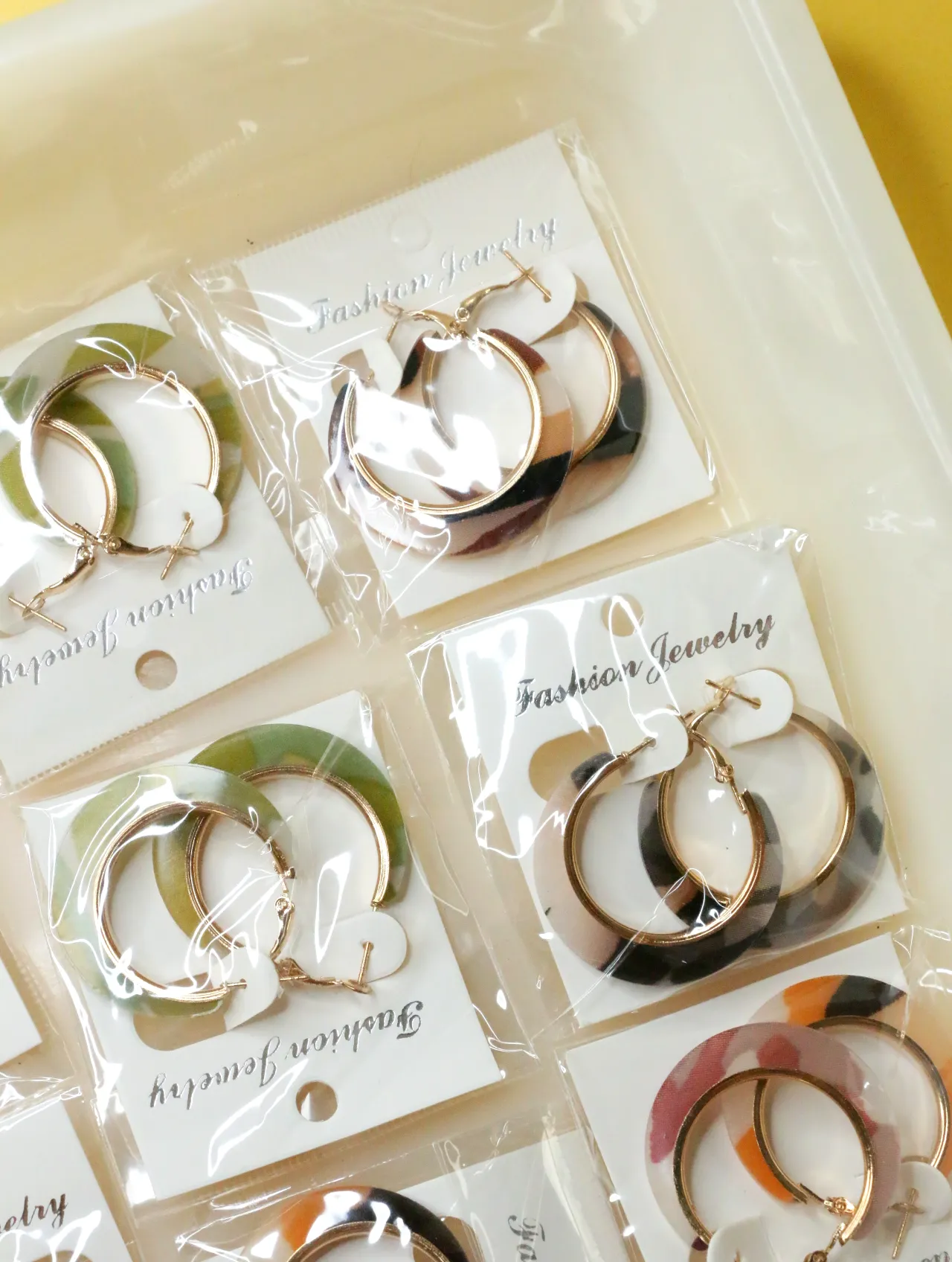 Pendientes de aro estampados envasados con detalles dorados — lote de bisutería de moda, vista lateral · Lola y Sol (H0009)