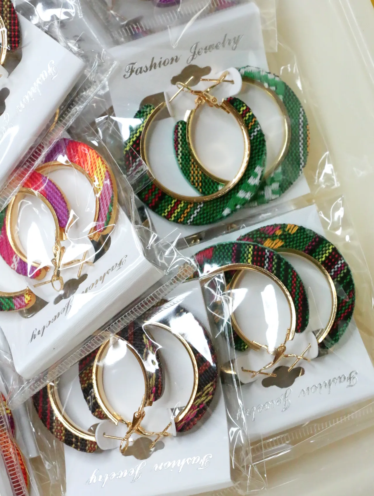Aros de tejido estampado verde con bordes en tono dorado — lote de bisutería de moda, vista lateral · Lola y Sol (H0010)