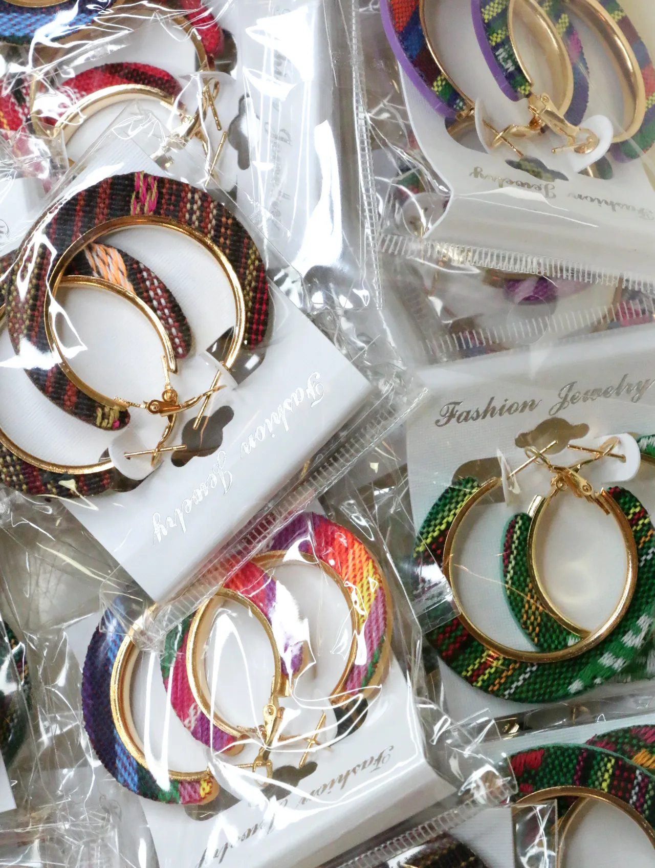 Surtido de pendientes de aro boho de tejido en envoltorios transparentes — lote de bisutería originales, detalle del acabado · Lola y Sol (H0010)