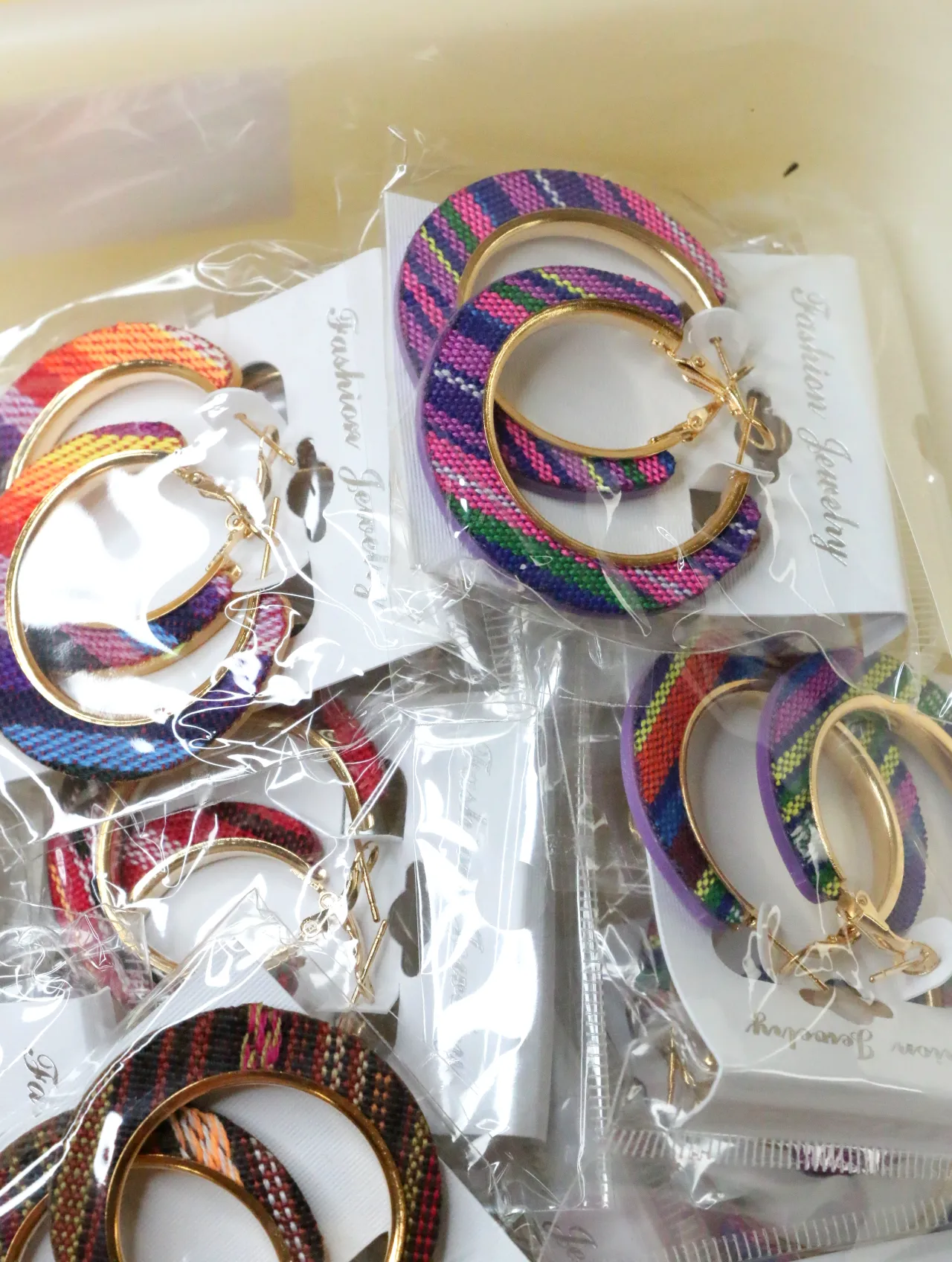 Pendientes de aro de tejido morado y multicolor sobre tarjetas — lote de bisutería online, vista principal · Lola y Sol (H0010)