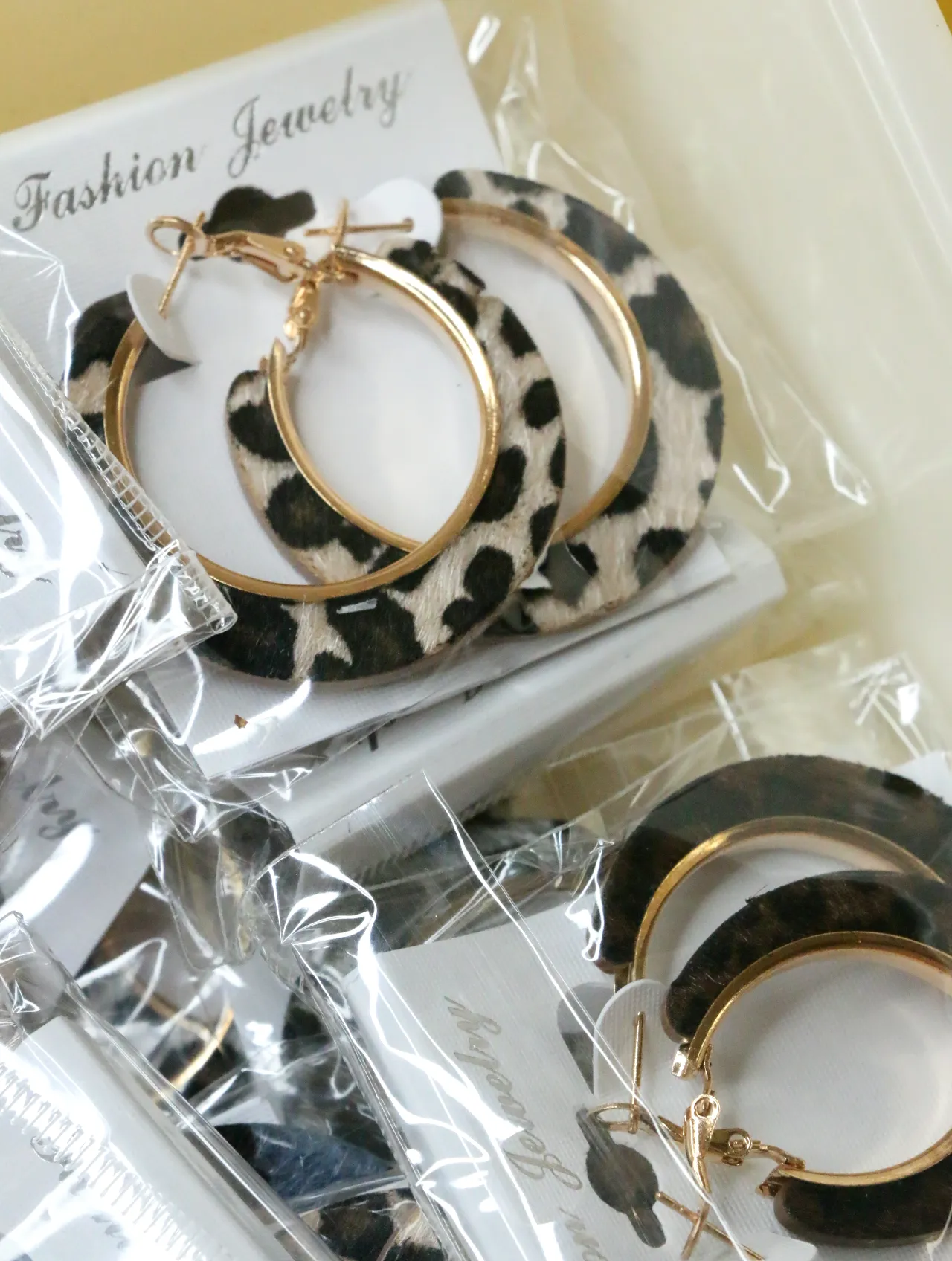 Detalle de aros de leopardo claro con acabados dorados — lote de bisutería originales, detalle del acabado · Lola y Sol (H0011)