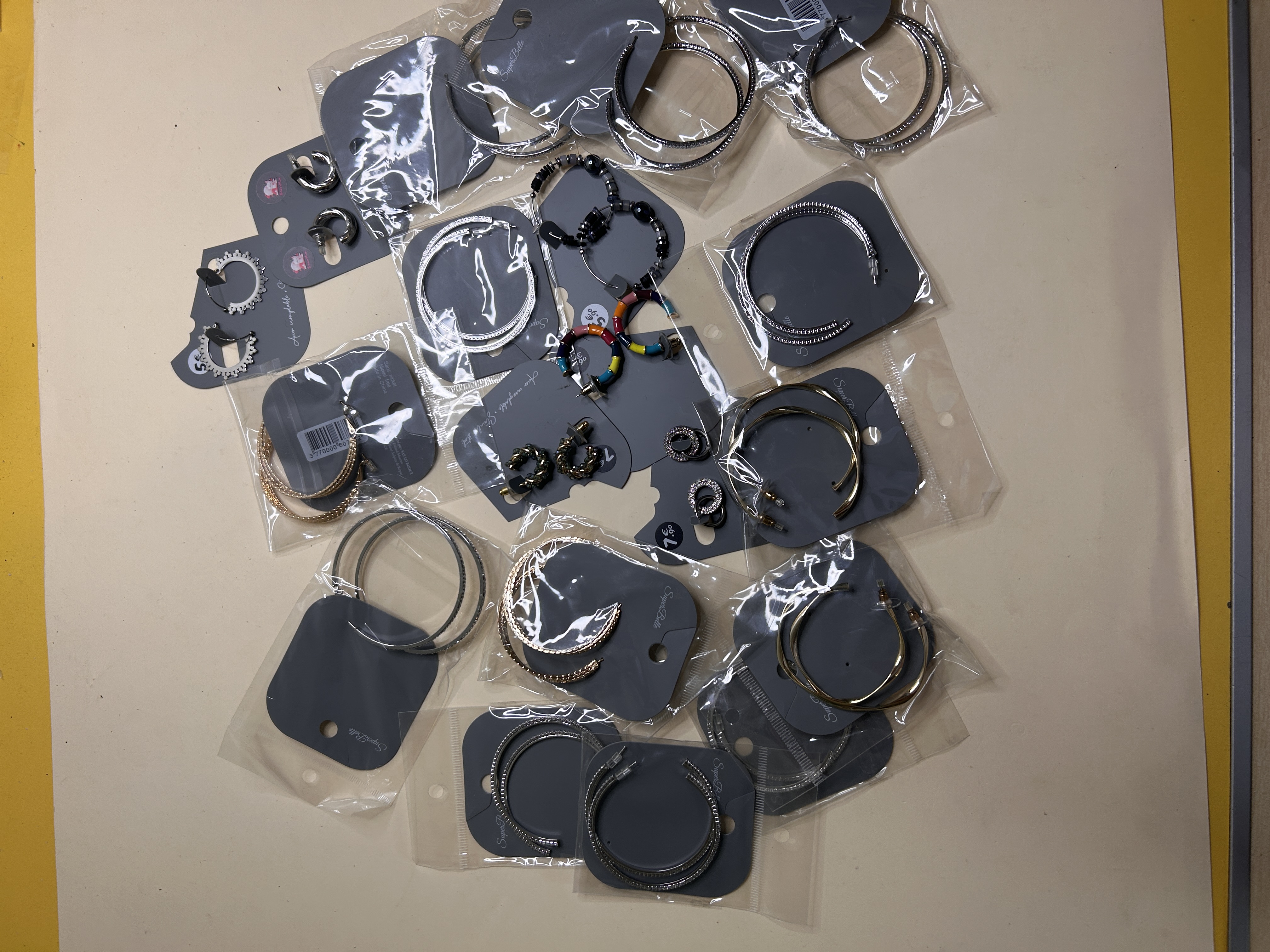 Variedad de pendientes de aro dorados y plateados sobre fondo blanco — lote de pendientes baratos, detalle · Lola y Sol (HOOP-204)