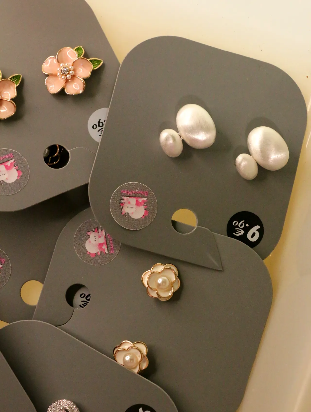 Pendientes ovalados efecto perla junto a diseños florales — lote de bisutería de moda, vista lateral · Lola y Sol (LOLA-P-BC-001)