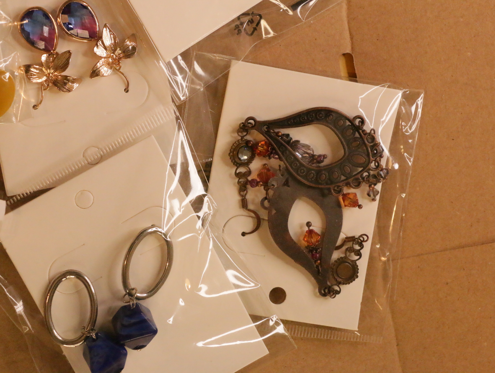 Pendientes ornamentales envejecidos junto a diseños colgantes morados y azules — lote de bisutería de moda, vista lateral · Lola y Sol (LT041)