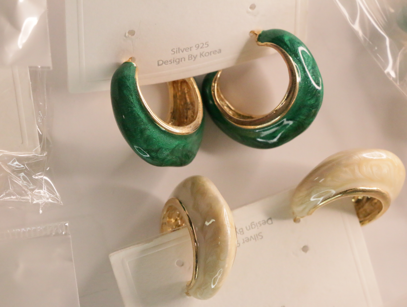 Pendientes de aro brillantes en verde intenso y crema — lote de bisutería de moda, vista lateral · Lola y Sol (LT045)