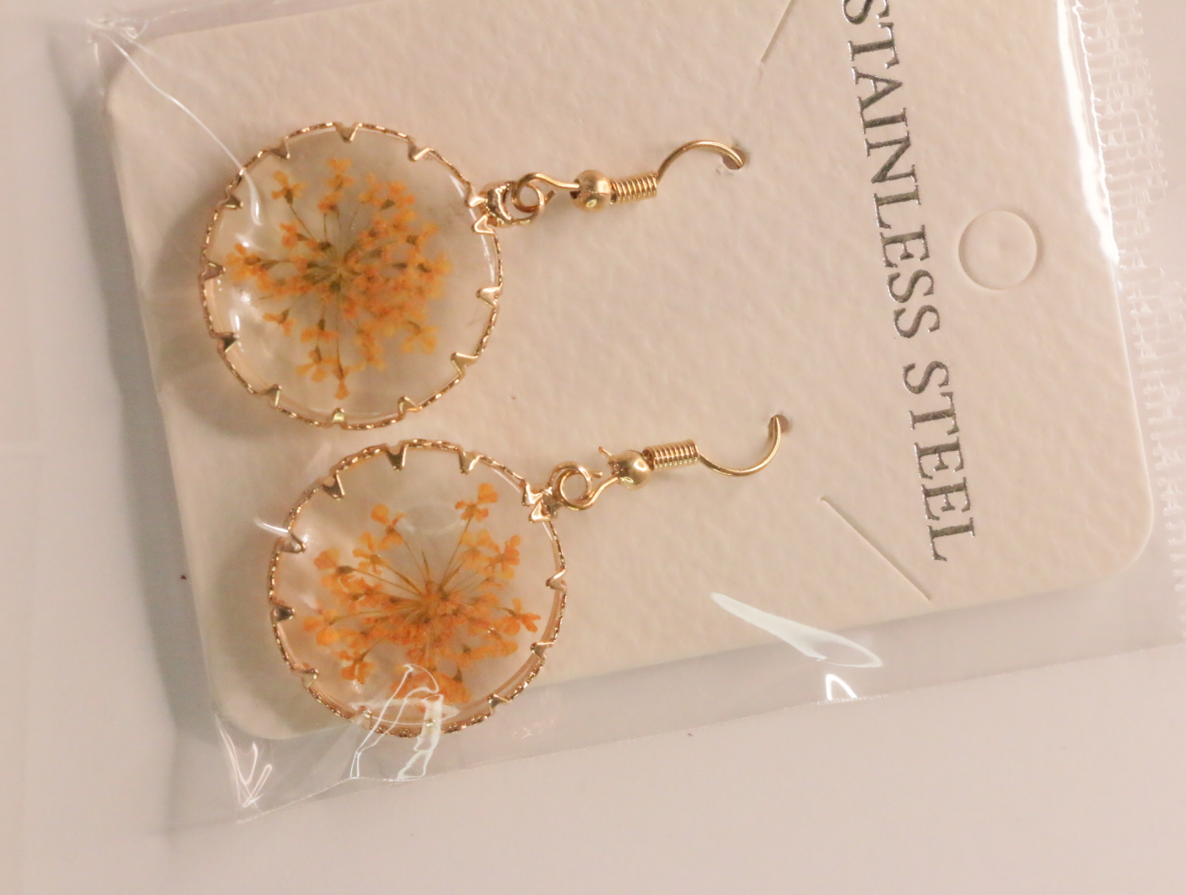 Pendientes redondos con detalles florales naranjas y bordes dorados — lote de bisutería de moda, vista lateral · Lola y Sol (LT046)