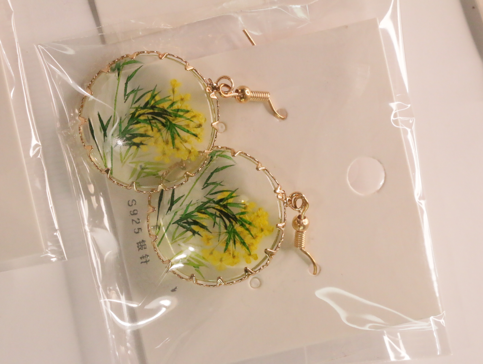 Pendientes de gancho dorado con colgantes de flores amarillas — lote de bisutería originales, detalle del acabado · Lola y Sol (LT046)