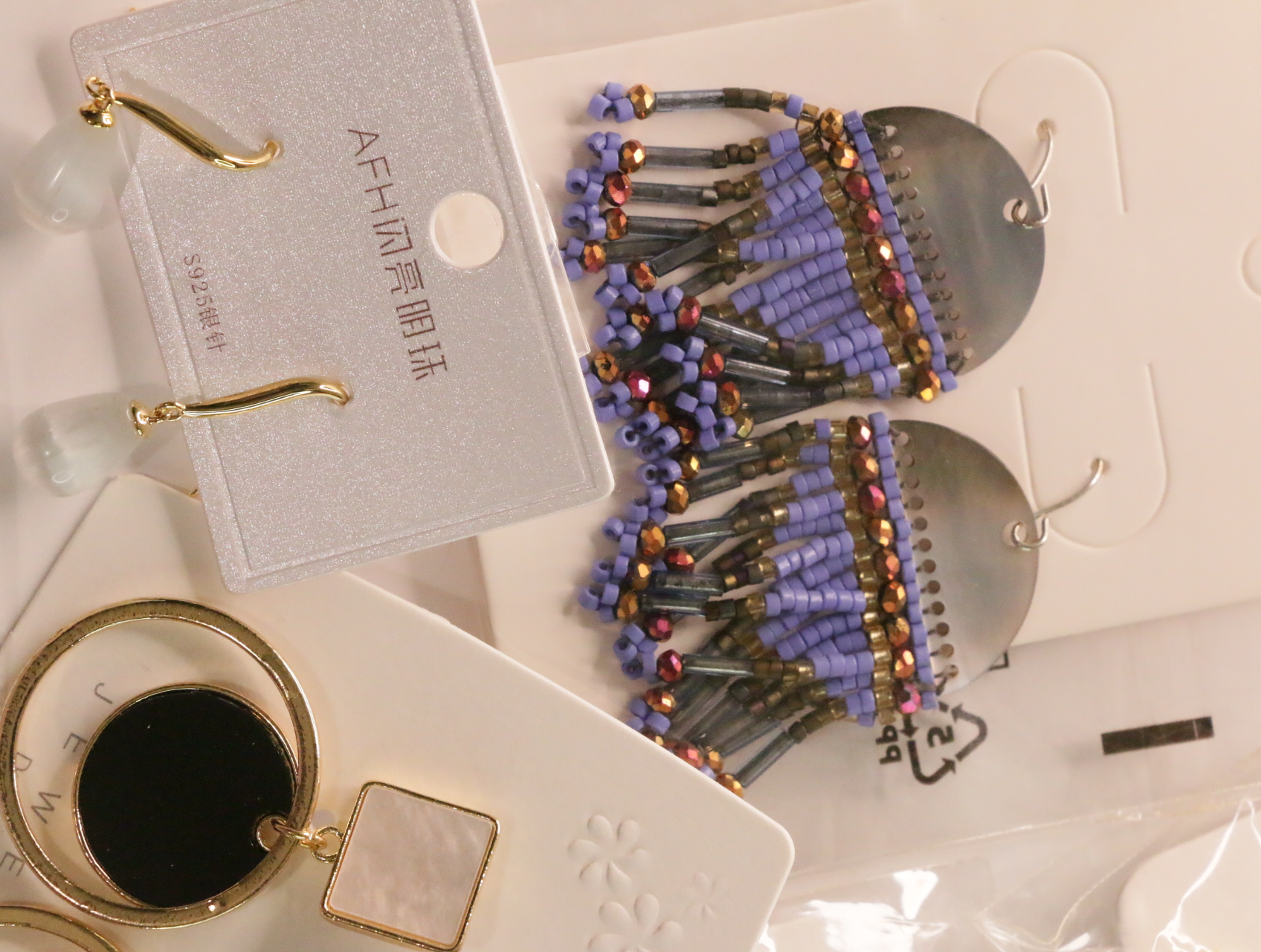 Pendientes boho con flecos de cuentas lilas junto a diseños geométricos — lote de bisutería dorados, primer plano · Lola y Sol (LT048)