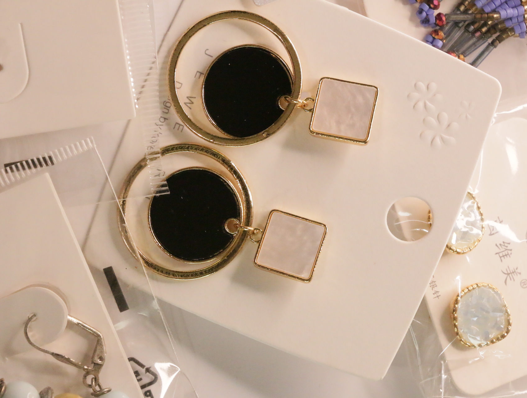 Pendientes geométricos con aros dorados y discos negros — lote de bisutería originales, detalle del acabado · Lola y Sol (LT048)