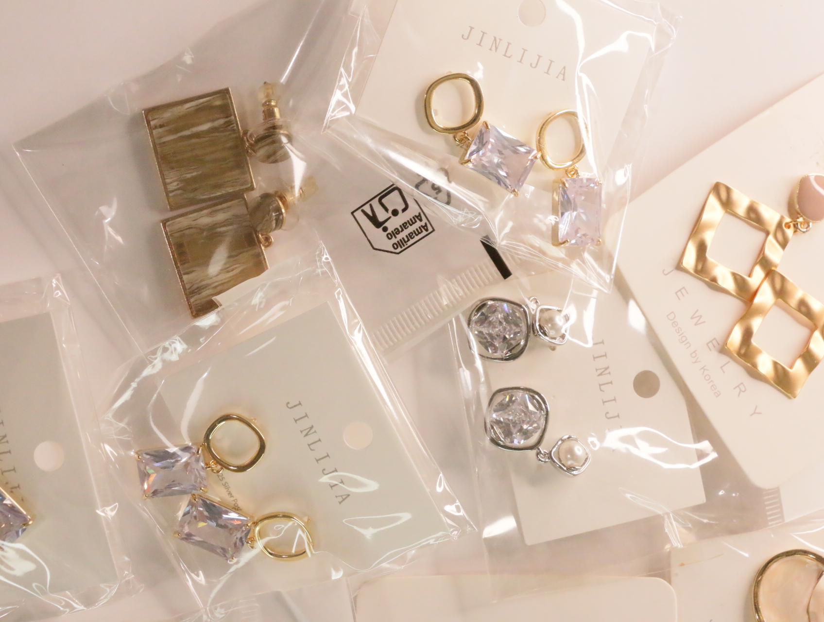 Pendientes variados con detalles transparentes facetados y acabados metálicos — lote de bisutería online, vista principal · Lola y Sol (LT049)