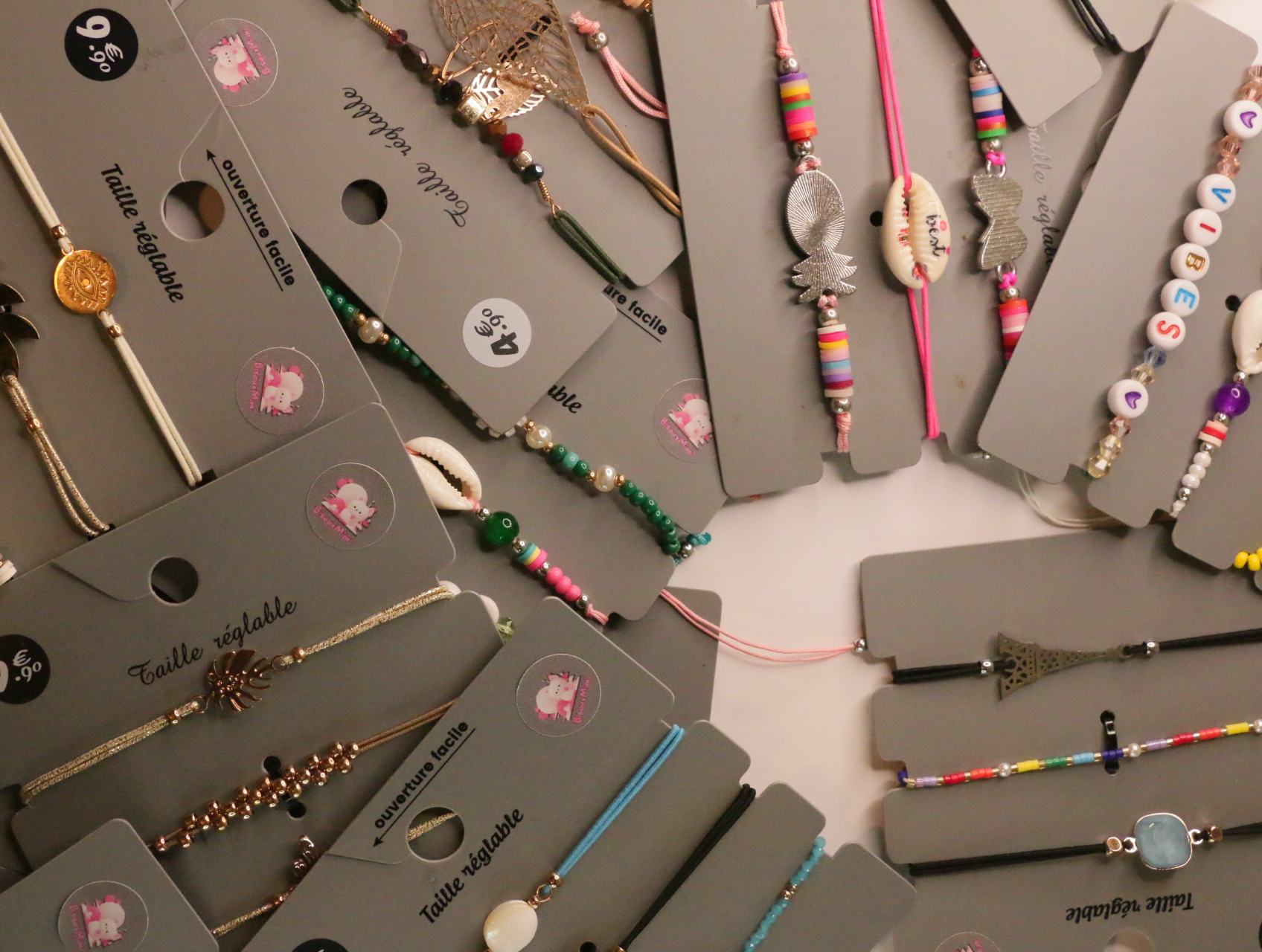 Pulseras multicolor con conchas, letras y motivos de piña — lote de bisutería originales, detalle del acabado · Lola y Sol (LT052)