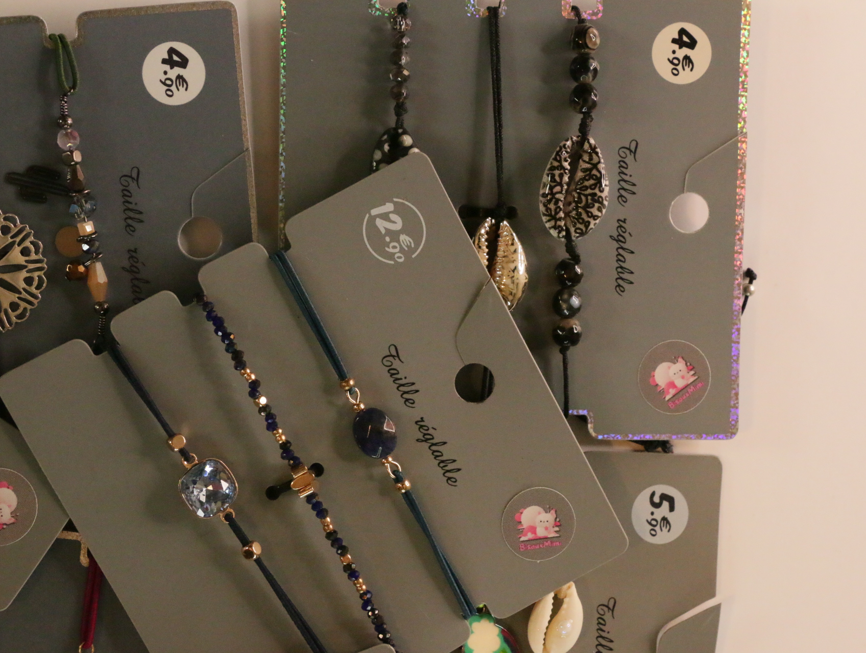 Detalle de pulseras de cordón con cuentas y adornos metálicos — lote de bisutería dorados, primer plano · Lola y Sol (LT053)