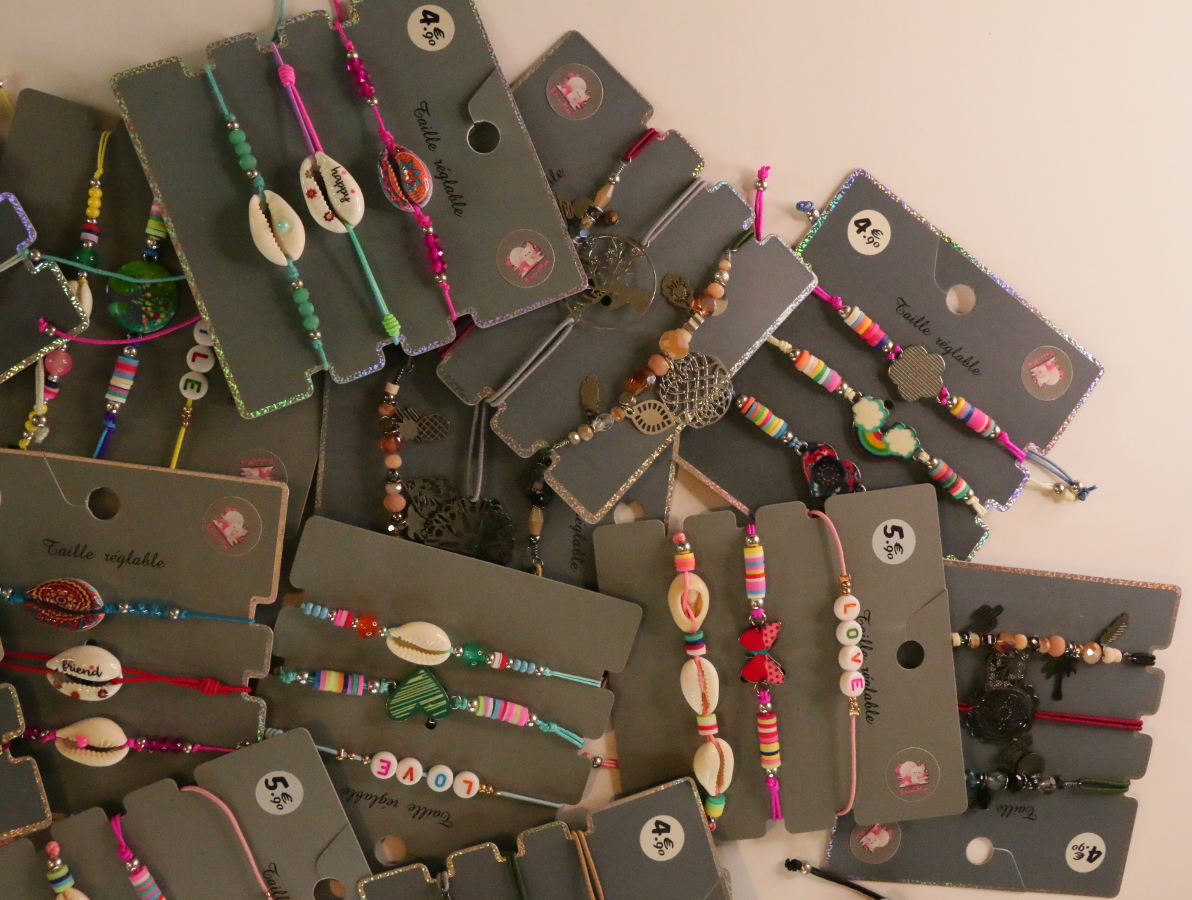 Pulseras con cordones de colores, conchas y colgantes metálicos — lote de bisutería dorados, primer plano · Lola y Sol (LT054)
