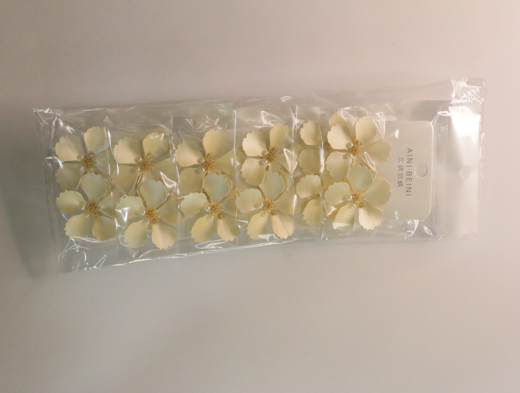 Vista del lote completo de pendientes de flores crema en sus envoltorios — lote de bisutería para mujer, vista principal · Lola y Sol (LT058)