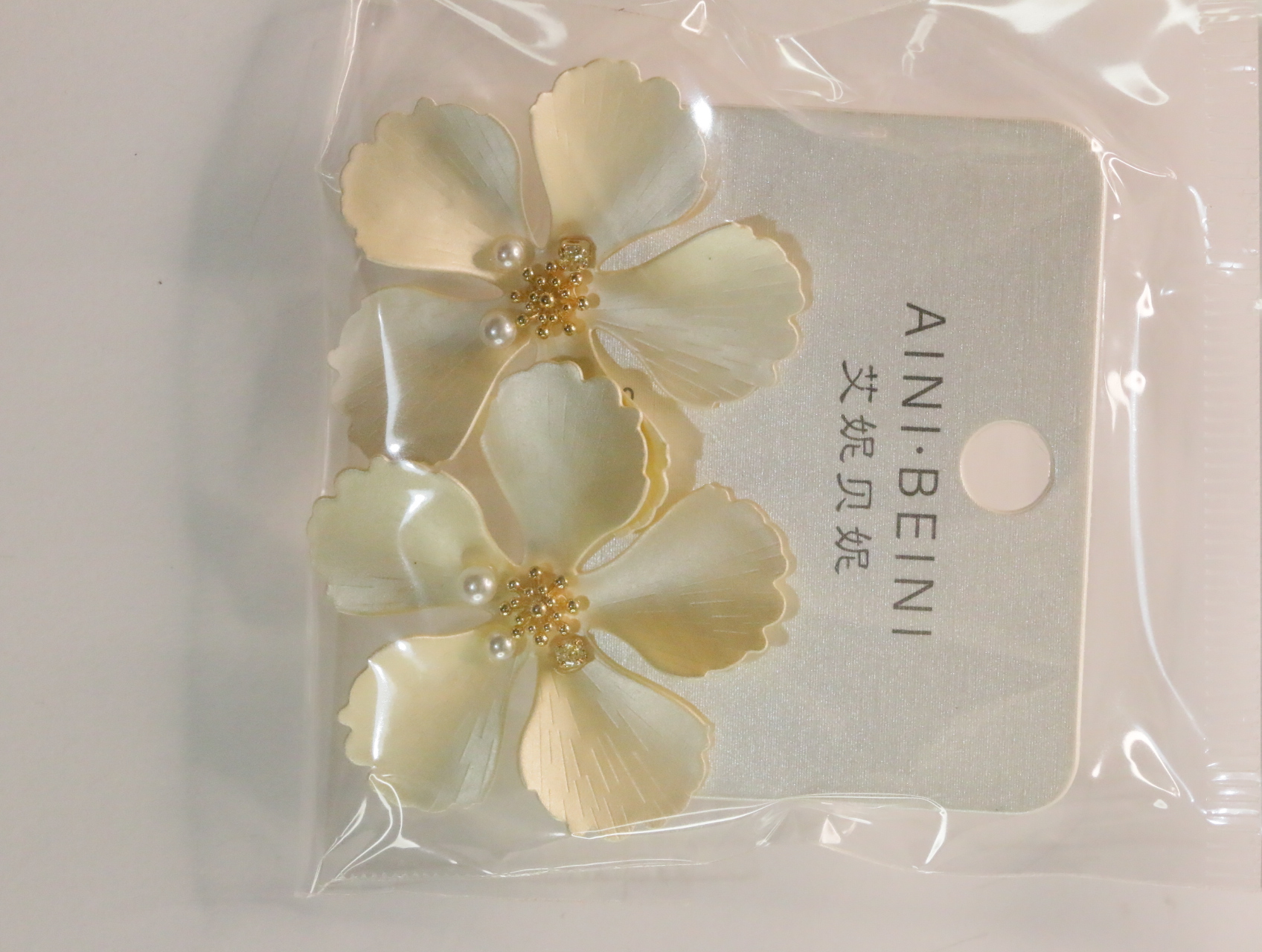 Detalle de pendientes de flores crema con centros dorados — lote de bisutería baratos, detalle · Lola y Sol (LT058)