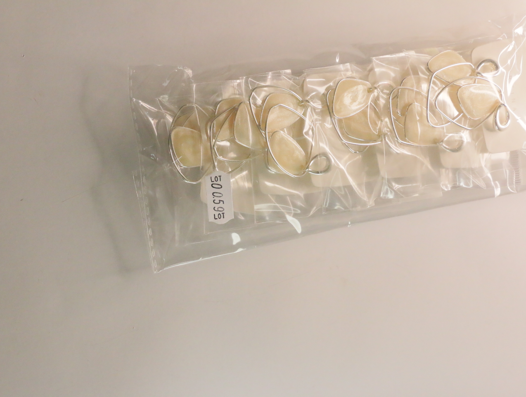 Pendientes largos envasados con etiqueta de referencia interna — lote de bisutería baratos, detalle · Lola y Sol (LT059)