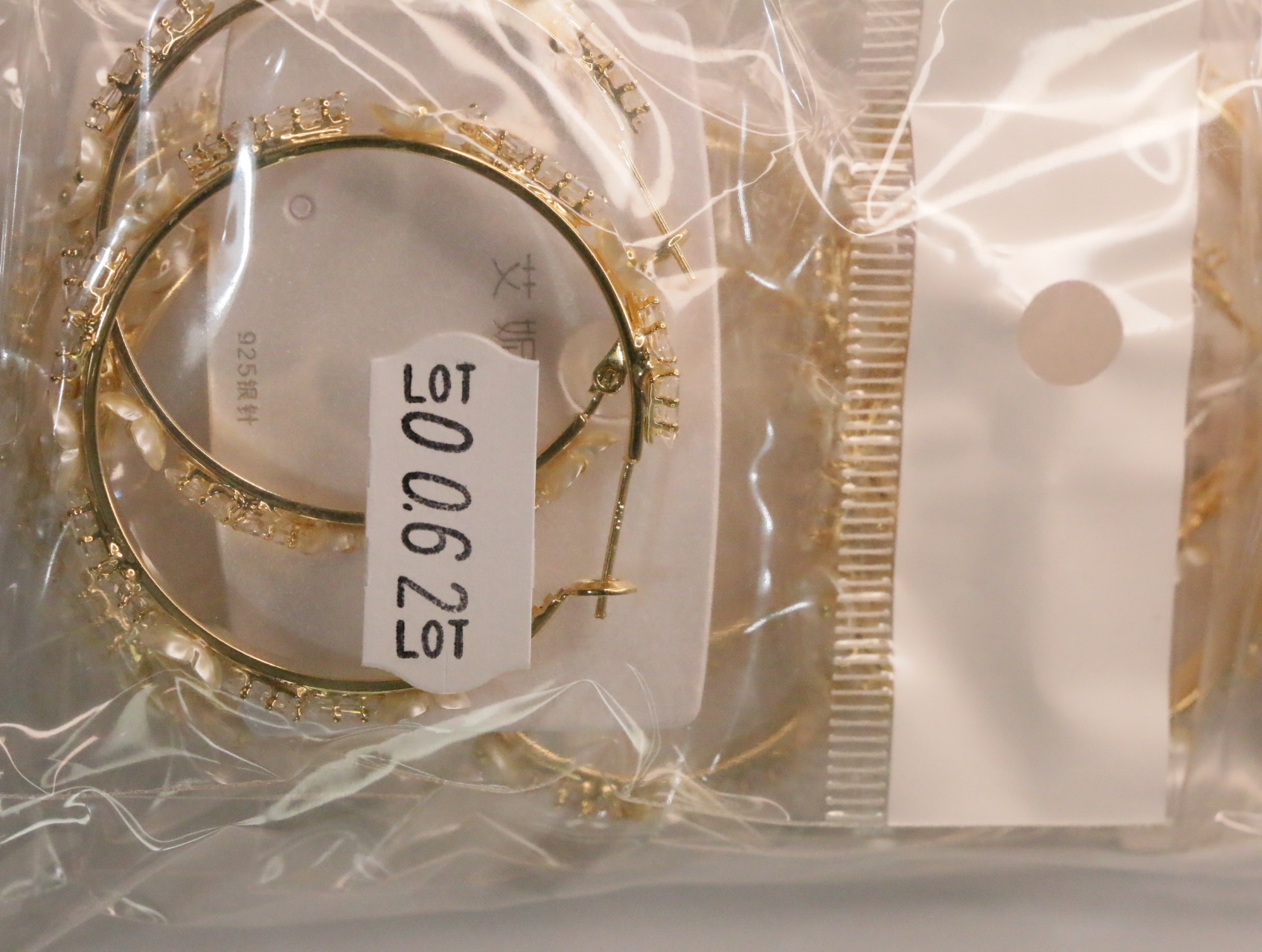 Pendientes de aro dorados con etiqueta de referencia interna — lote de bisutería de moda, vista lateral · Lola y Sol (LT062)