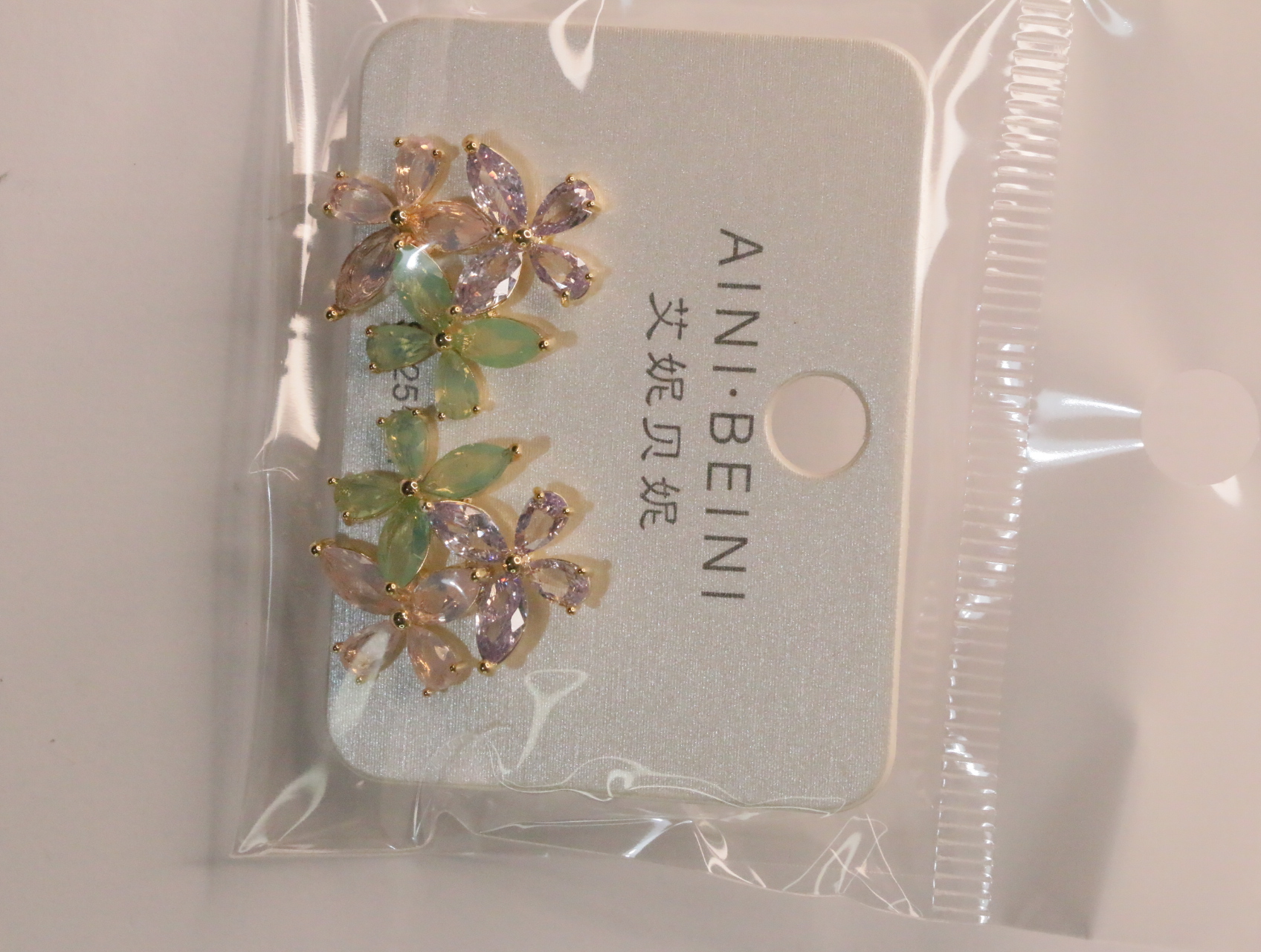 Pendientes florales dorados con piedras rosas y verdes — lote de bisutería dorados, primer plano · Lola y Sol (LT064)