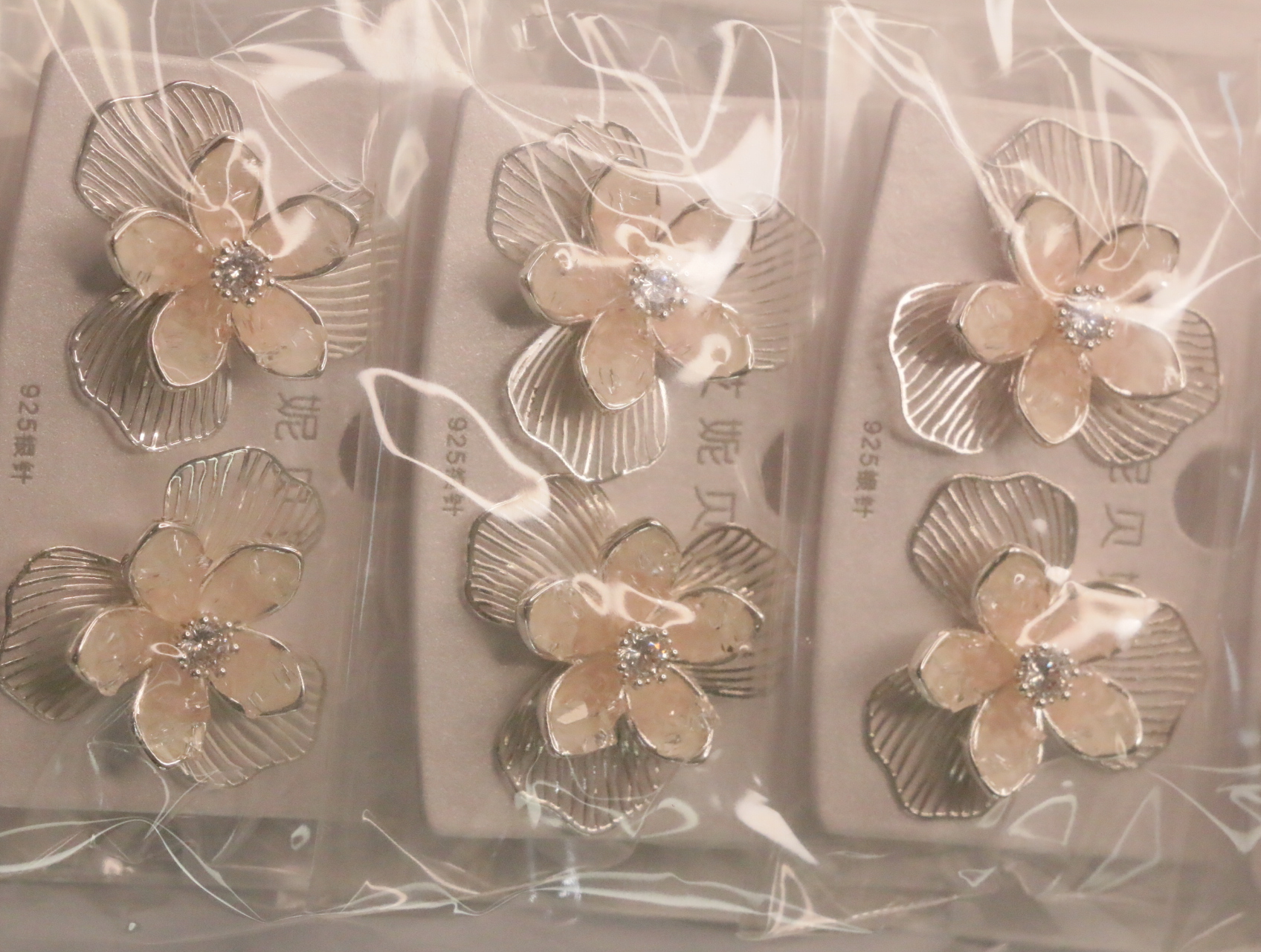 Detalle de pendientes florales melocotón con pétalos metálicos texturizados — lote de bisutería baratos, detalle · Lola y Sol (LT066)