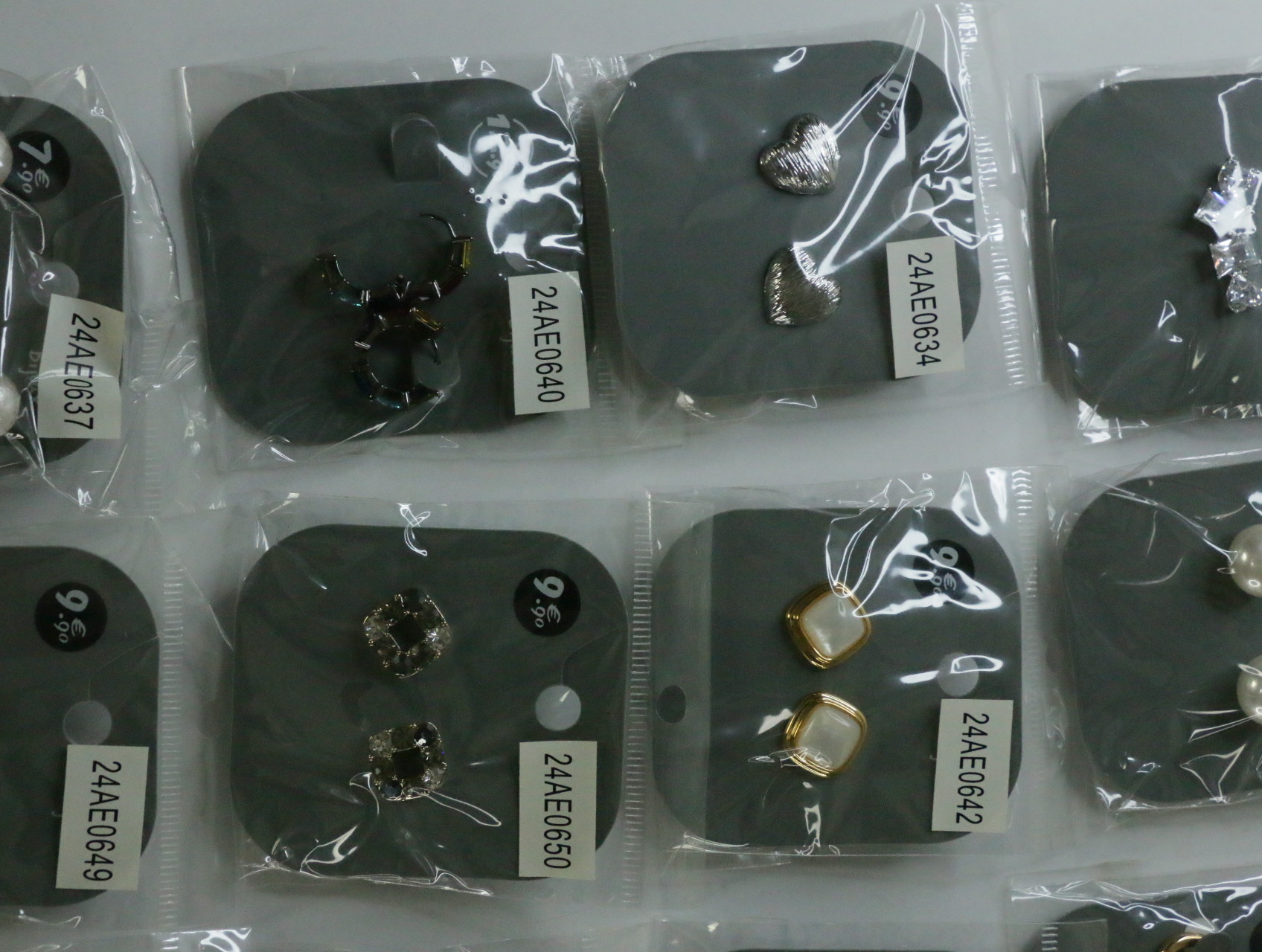 Pendientes plateados texturizados junto a diseños oscuros y nacarados — lote de bisutería originales, detalle del acabado · Lola y Sol (LT070)