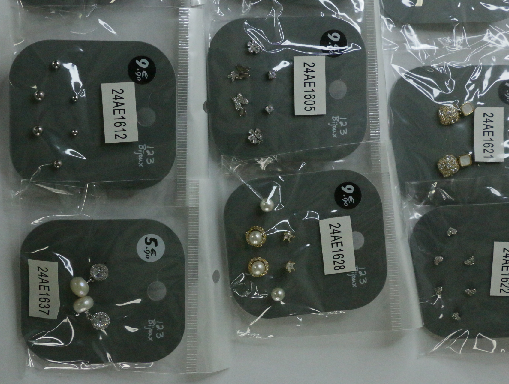 Pendientes plateados y de efecto perla en envoltorios protectores — lote de bisutería de moda, vista lateral · Lola y Sol (LT072)
