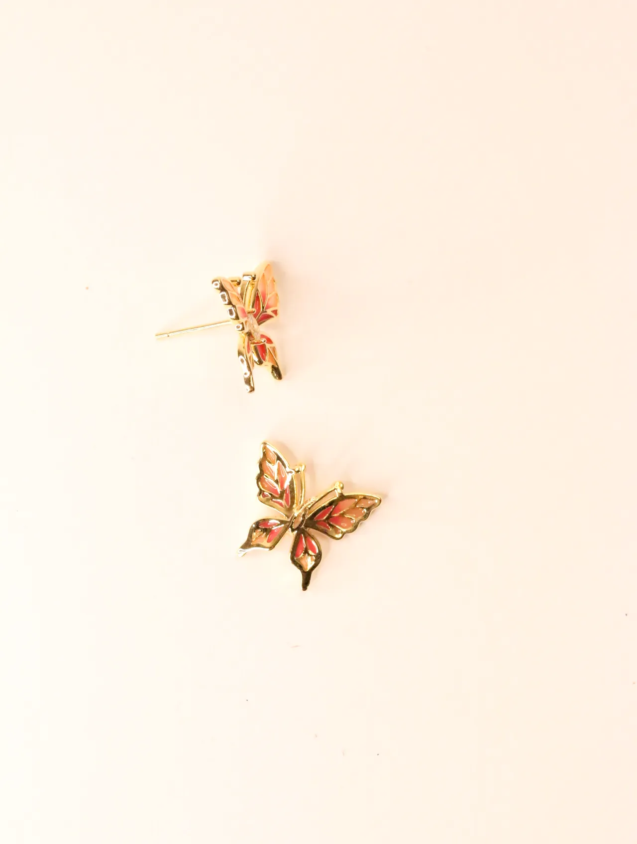 Par de pendientes de mariposa, uno mostrando el perno, sobre un fondo blanco liso. — pendientes dorados, primer plano · Lola y Sol (PO-PD-43)